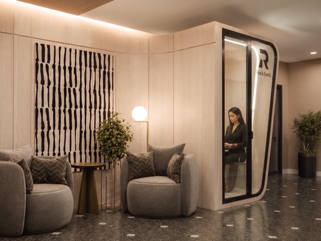 Sala de espera con butacas y phone booth
